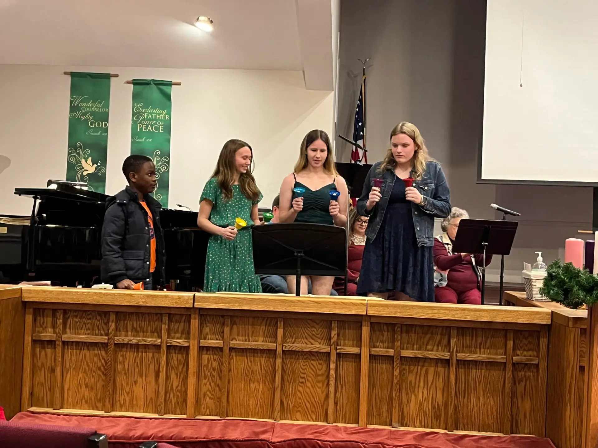 A few youth group members play handbells during the Christmas Eve 2023 service.
