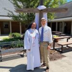 Pastor Antoinette and Weston both stand in front of the NEUMC cross for a photo during Easter Sunday.