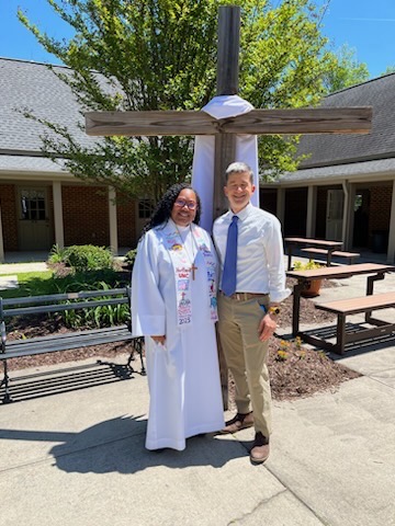 Pastor Antoinette and Weston both stand in front of the NEUMC cross for a photo during Easter Sunday.