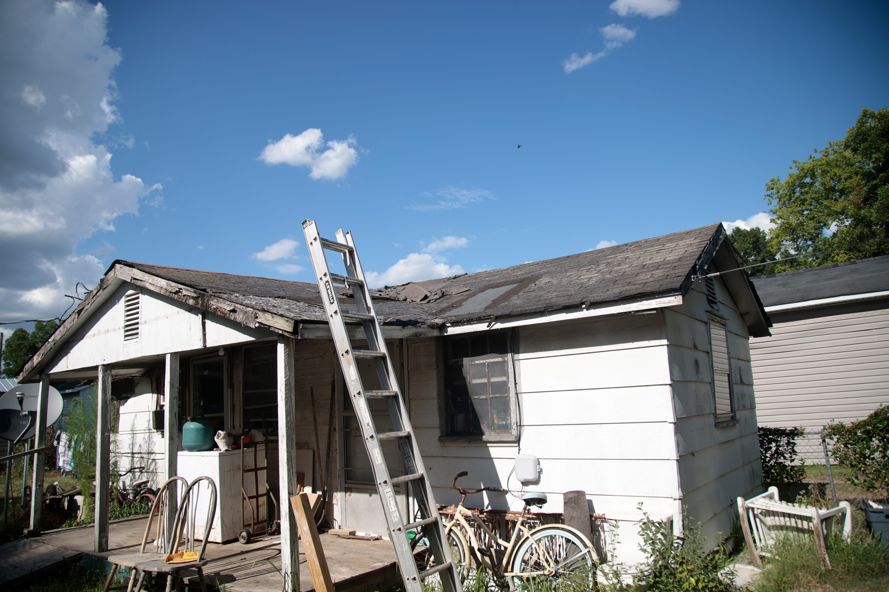 A picture of a 2024 salkehatchie site. There is a ladder leading up to a badly damaged roof with debris on top of it.