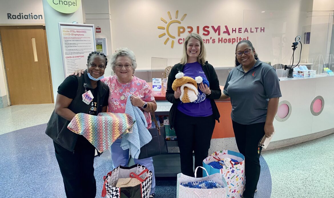 A group of volunteers pose for a photo at Prisma Health after donating prayer shawls.