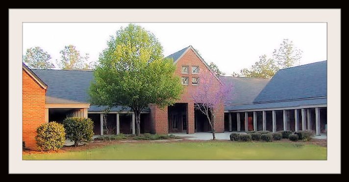 A picture of the church campus that includes the front lawn, office building, nursery building, and sanctuary,