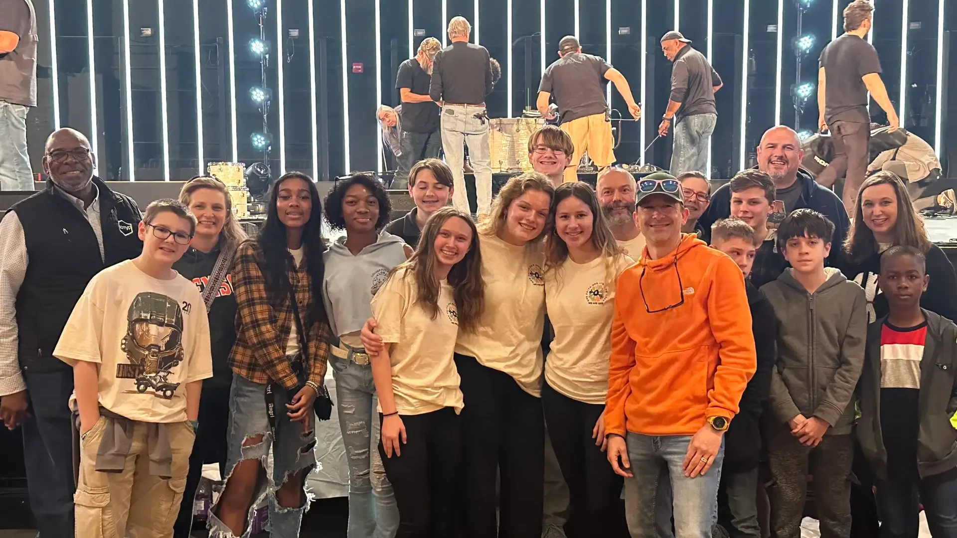 Revolution 2023 youth group A group of NEUMC youth members, with Revolution 2023 shirts on, pose for a picture in front of the stage at Township Auditorium