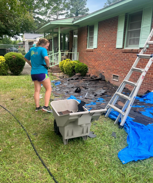 A picture of a Salkehatchie volunteer looking down at debris cleared from a roof.