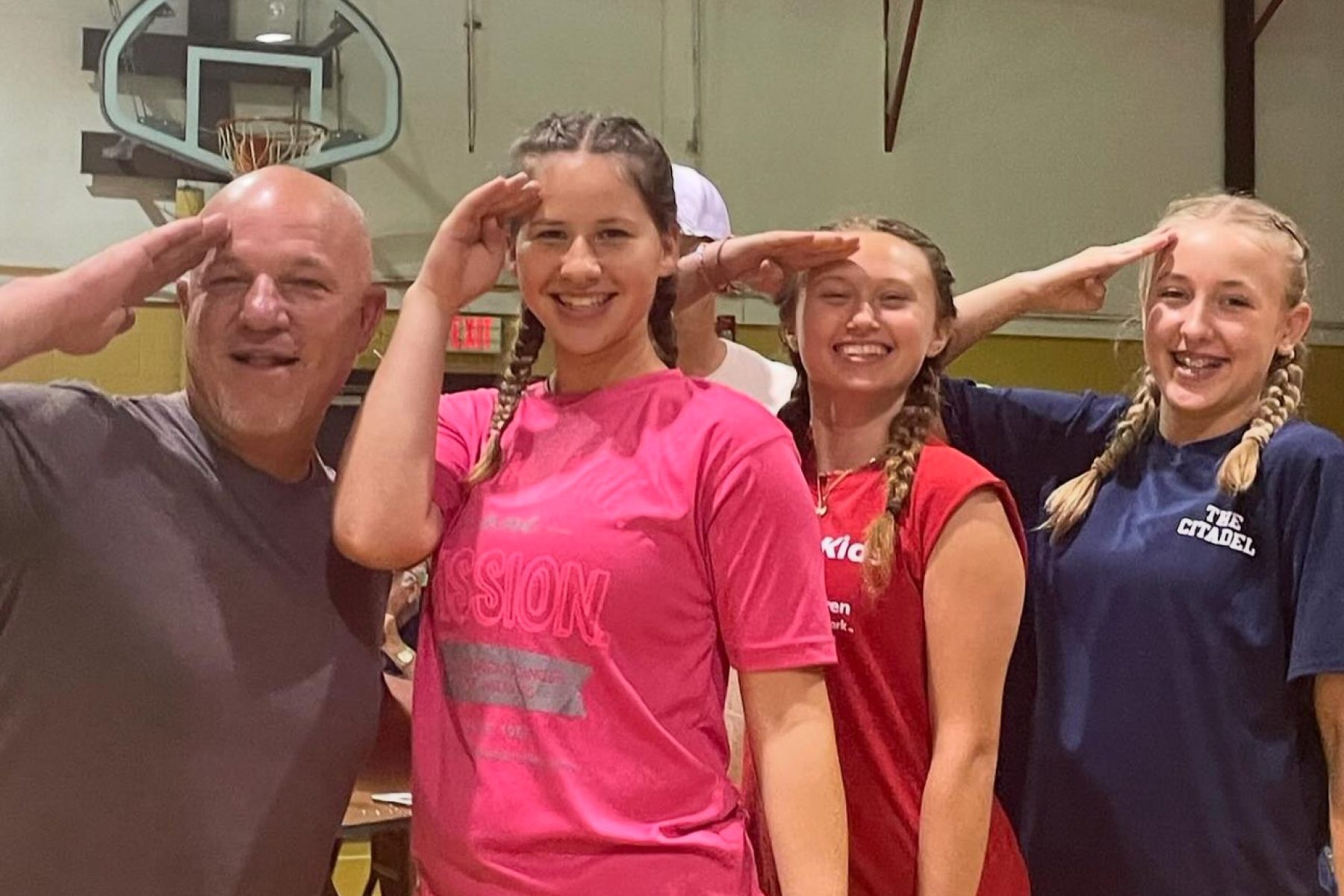 A picture of 4 salkehatchie volunteers posing for a photo. They are all saluting